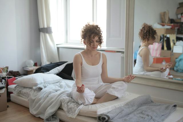 Andrea-piacquadio-Calm-woman-in-lotus-pose-meditating-after-awakening-at-home
